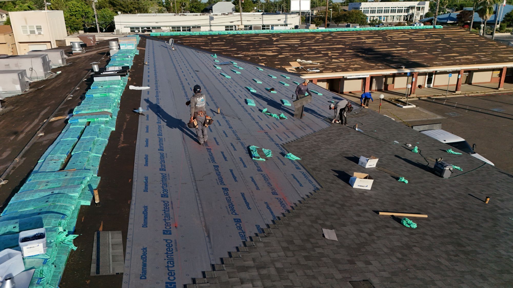GM Roofing crew installing CertainTeed Landmark Solaris shingles over DiamondDeck underlayment on an Arden strip mall