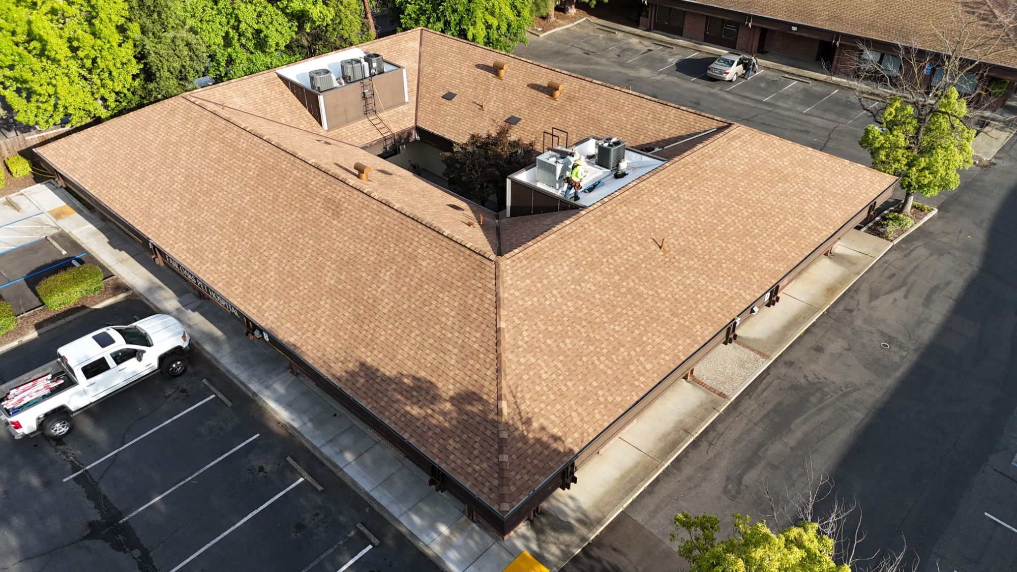 Corner view of the new Resawn Shake hip roof and ridge vent on the Fair Oaks Pet Hospital